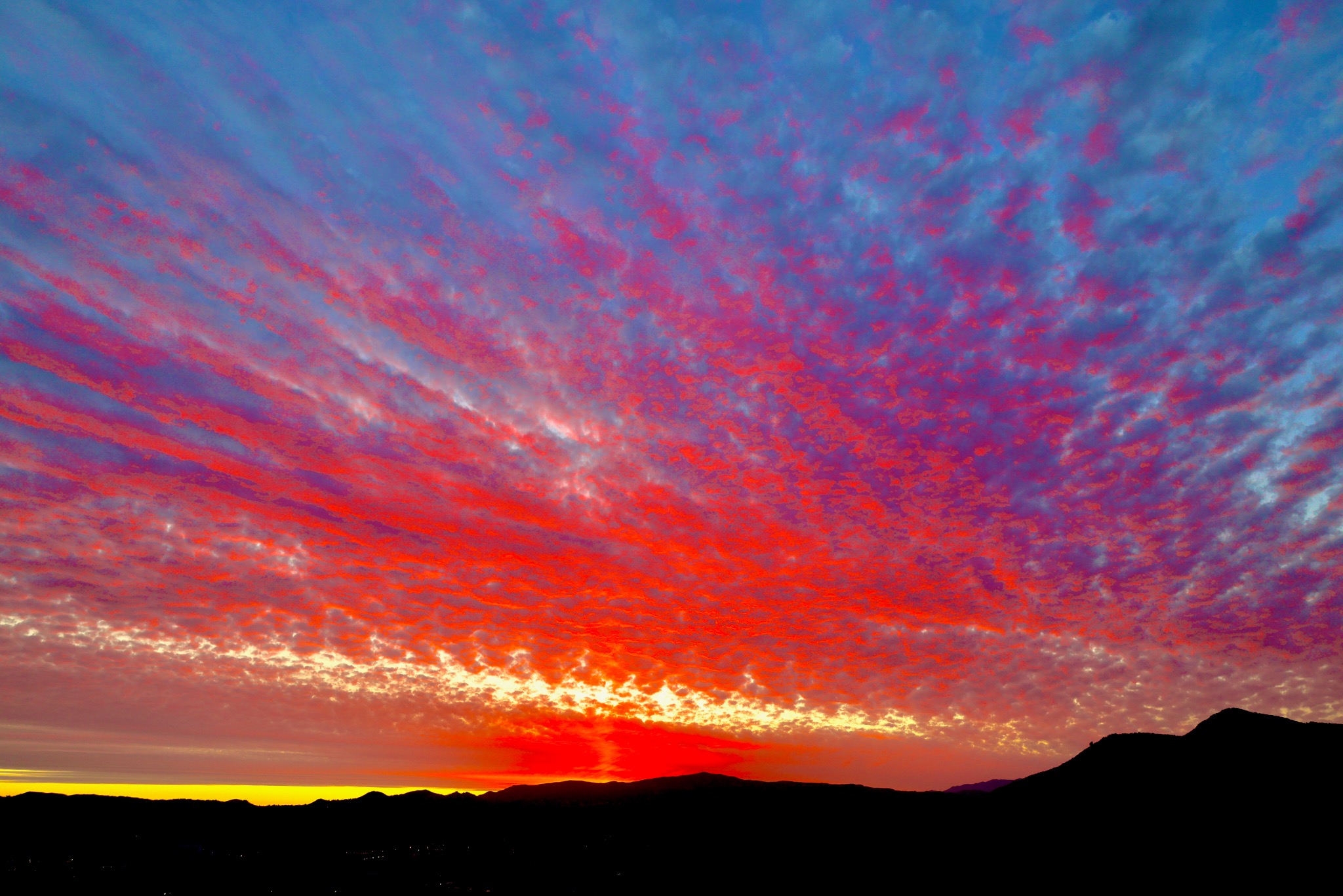 Radiant red and purple sunset over distant mountains